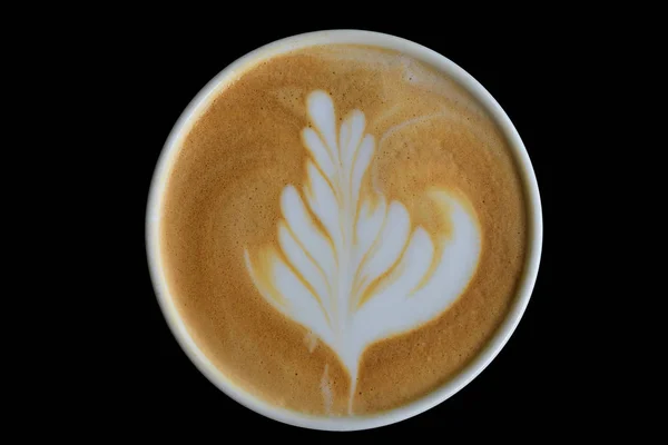 Koyu ahşap masada latte sanatının üst görünümü.   