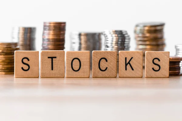 Stocks Spelled Out Wooden Tiles Coins Background — Stock Photo, Image
