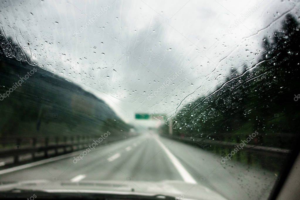 Windshield full with water drops on heavy rain on highway, Germany