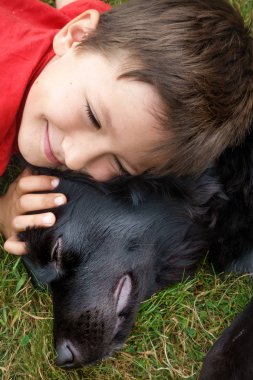 oğlan ve köpek Belçika çim üzerinde yalan