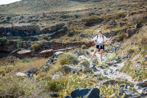 Kayalık manzara üzerinde duran kadın uzun yürüyüşe çıkan kimse