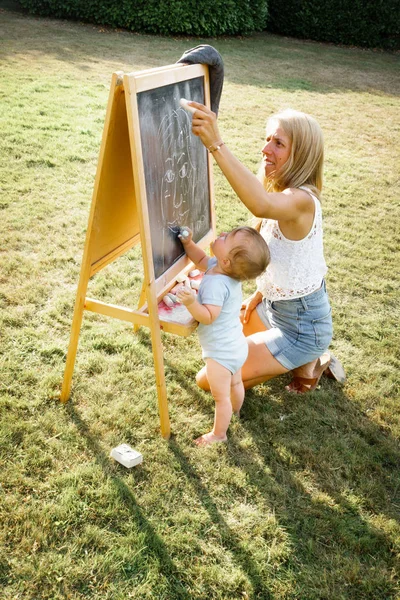 Moeder Met Baby Meisje Tekening Blackboard Buitenshuis Gras — Stockfoto