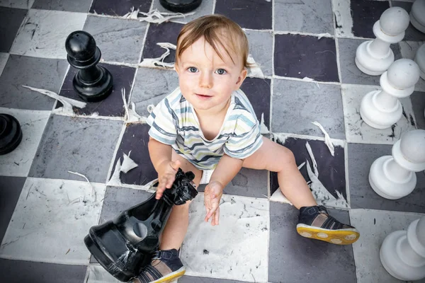 Kleiner Junge Sitzt Auf Schachbrett Mit Schachfigur — Stockfoto