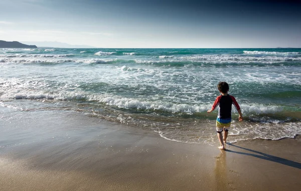 在希腊克里特 男孩走进大海的看法 — 图库照片