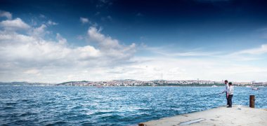 İki adam balık tutuyor.