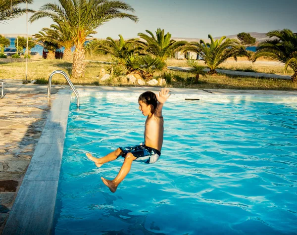 Niño saltando en la piscina — Foto de Stock