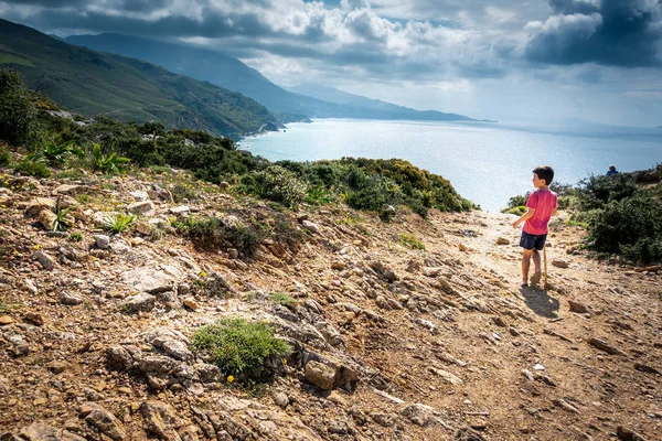 पहाड़ों पर समुद्र की सुंदरता की प्रशंसा करने वाले लड़के के पीछे का दृश्य, ग्रीस — स्टॉक फ़ोटो, इमेज