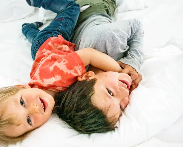 Dos hermanos divirtiéndose en la cama — Foto de Stock
