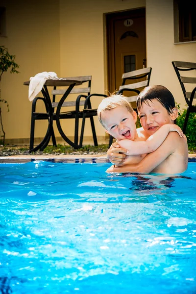 Glückliche Brüder, die sich umarmen und im Pool spielen, Griechenland — Stockfoto