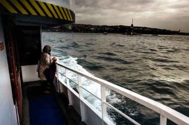 Kız Kulesi'ni tekneden hayranlıkla gösteren kadın