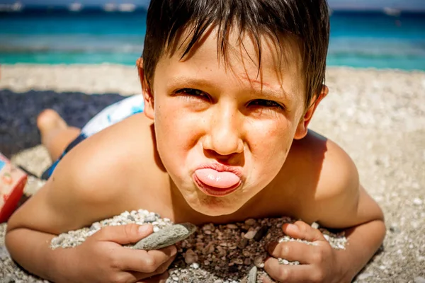 Portret chłopca leżącego na plaży — Zdjęcie stockowe