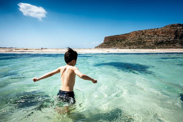 Chlapec s vodou na pláži — Stock fotografie