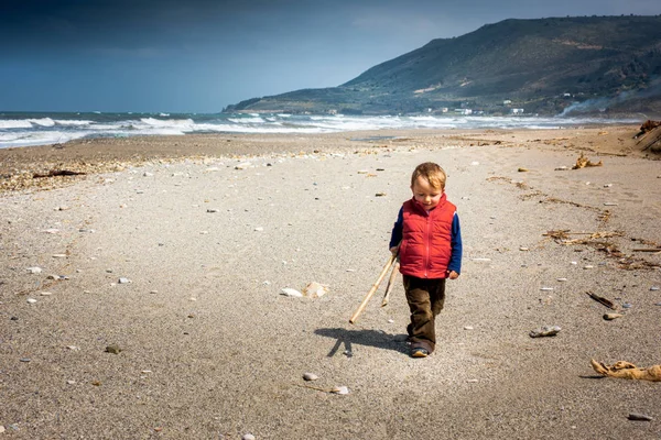 Menino com pau na praia — Fotografia de Stock