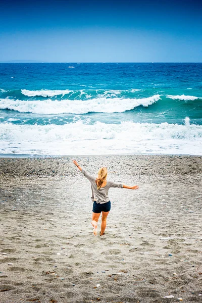 Vue arrière de la femme courant sur la plage — Photo