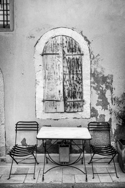 Mesa e cadeira colocadas na frente da janela de madeira — Fotografia de Stock