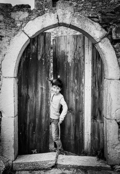 Junge blickt durch Holztür — Stockfoto