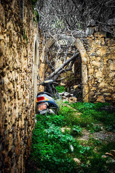 Scooter obsoleto estacionado junto a un muro de piedra — Foto de Stock
