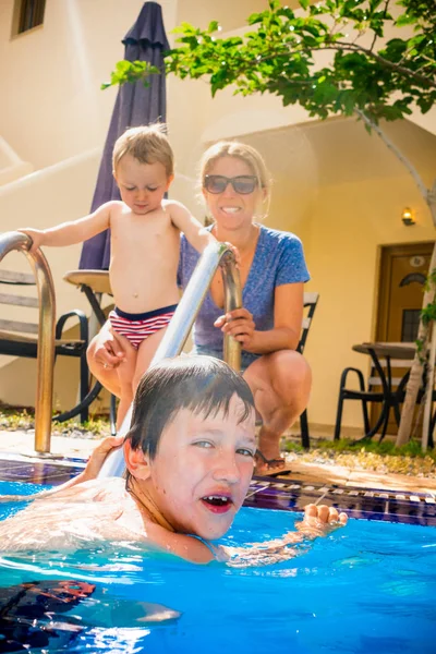 Niños felices nadando en la piscina con su madre — Foto de Stock