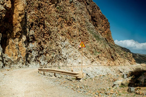 Narrow road ahead sign by railing — Stock Photo, Image