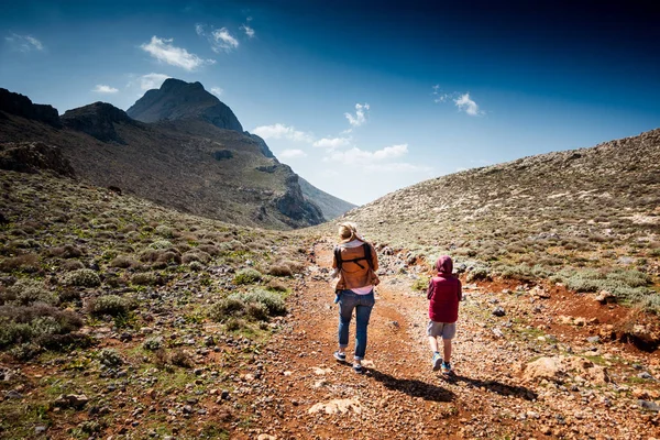 Bakifrån av kvinnan med barn vandring på berget — Stockfoto