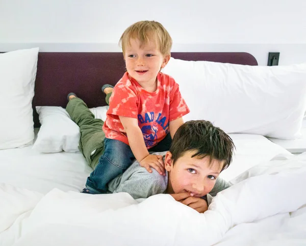 Dva bratři se na posteli baví — Stock fotografie