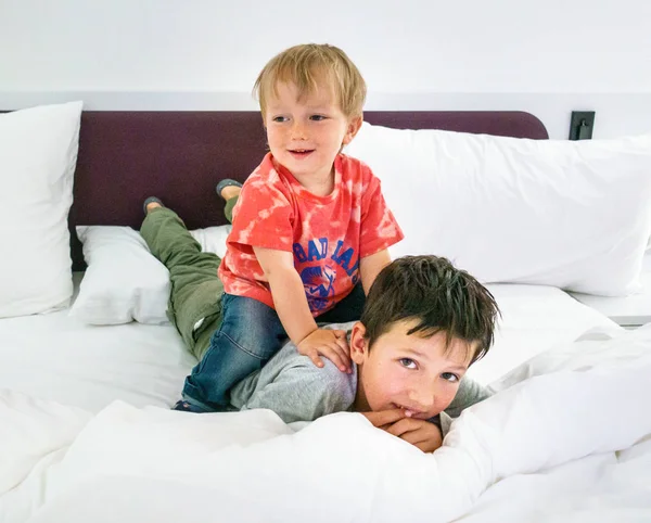 Dois irmãos se divertindo na cama — Fotografia de Stock