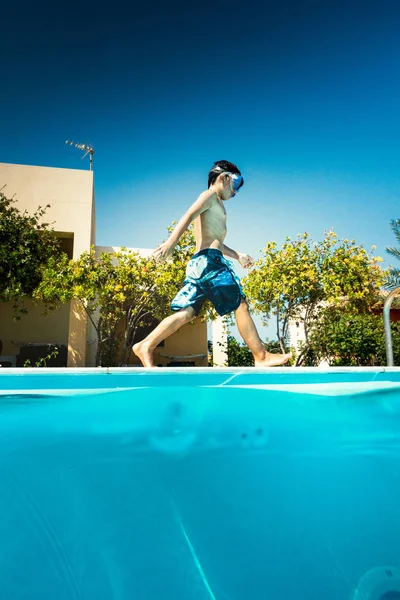Мальчик ходит у бассейна — стоковое фото