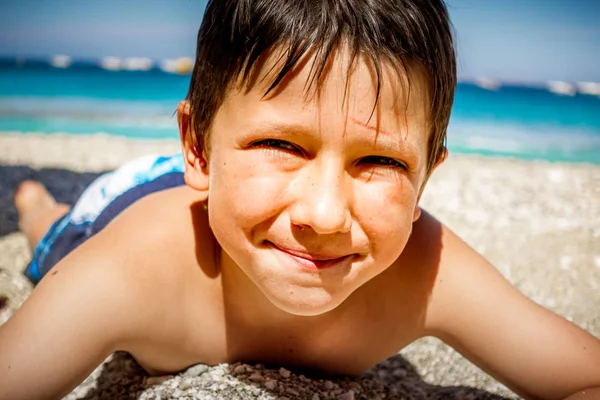 Portret chłopca leżącego na plaży — Zdjęcie stockowe