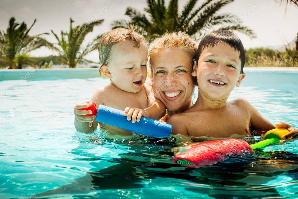 Mother with children in swimming pool