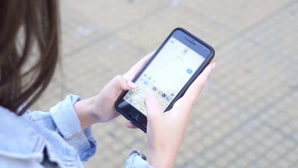 Tenåringsjente skriver og sender SMS på smarttelefon – stockvideo