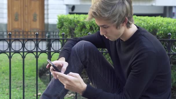 Tiener jongen texting bericht op smartphone — Stockvideo