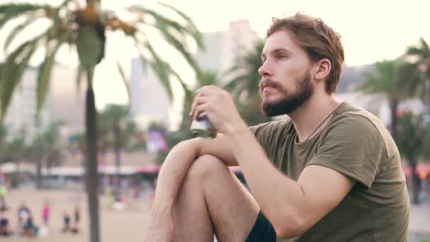 青年男子在城滨喝啤酒 — 图库视频影像