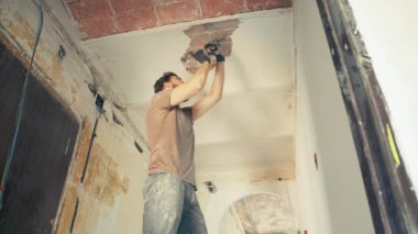 Daire yenileme işinde çalışan genç adam.