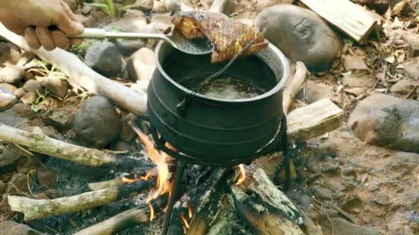 Cocinar pescado en maceta en fogata — Vídeo de stock