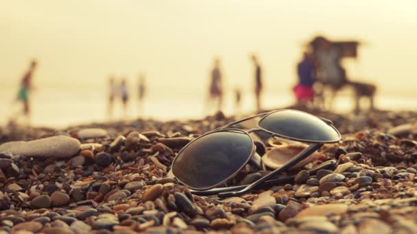 Solbriller på strand og købmand passerer – Stock-video