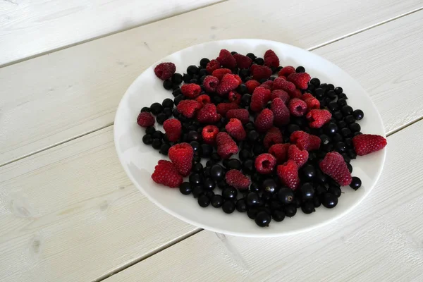 Замороженные ягоды на белом деревянном столе — стоковое фото