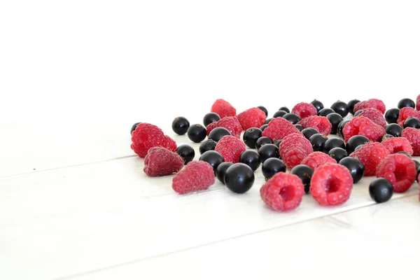 Raspberry and black currant on wooden table — Stock Photo, Image