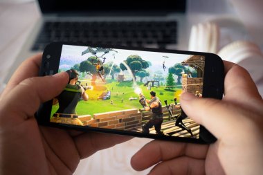 Nizhyn, Ukrayna/16-Temmuz 2019: Akıllı telefon ve playi tutan eller