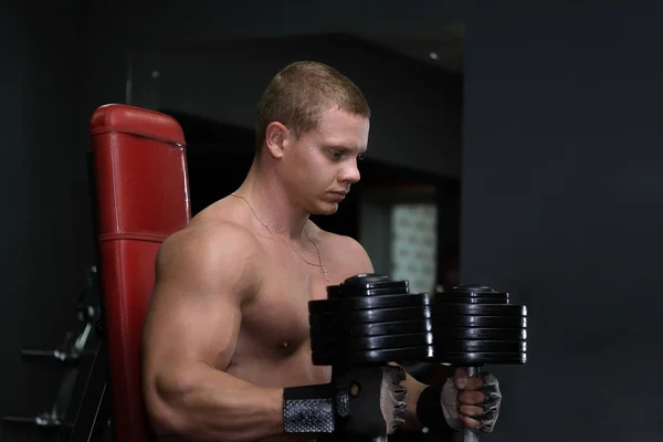 Tezgah ve Loo üzerinde spor salonunda oturan Dambıl ile genç adam