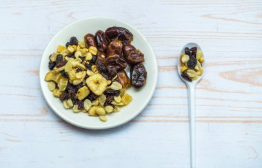 Sağlıklı gıda, tabakta kurutulmuş meyve ve kaşık. abov'dan görünüm
