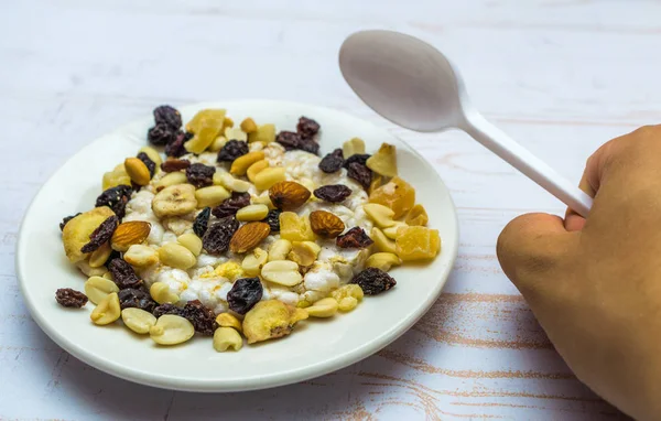 Close-up of rice waffles and dried fruit on the plate with hand