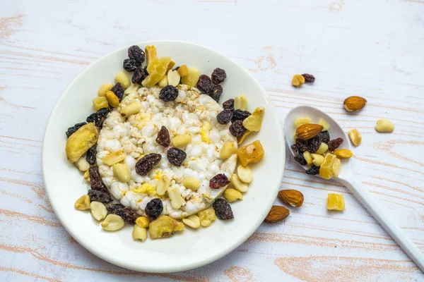 Mix of rice waffles and dried fruit on the plate and spoon. View