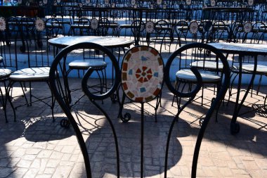 Açık bir restoranda siyah renkli bir mealllic sandalyenin bir parçası. çok daha fazla sandalye ve masalar da aynı tür arka planda görülür