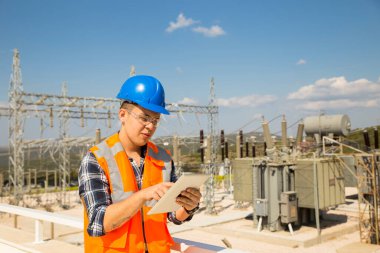 Genç mühendis elektrik santralini arıyor ve kontrol ediyor.