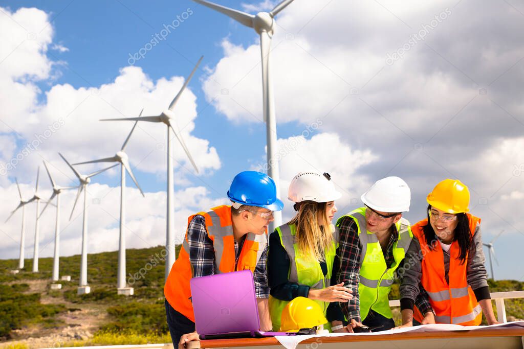 Young engineers and workers having a meeting at wind farm