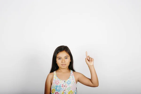 Niña apuntando a la derecha de la pantalla sobre fondo blanco . — Foto de Stock