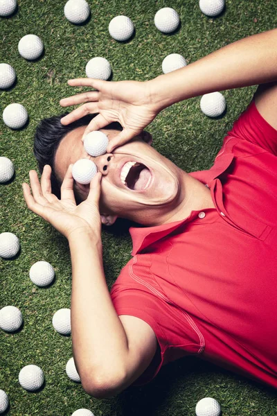 Golf spelare på golvet med bollar på ögonen. — Stockfoto
