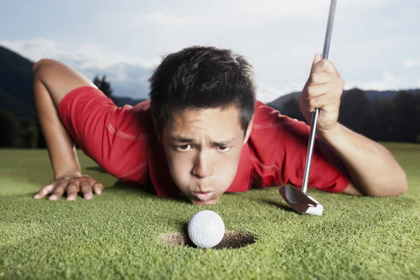 Golfare blåser bollen i kopp. — Stockfoto