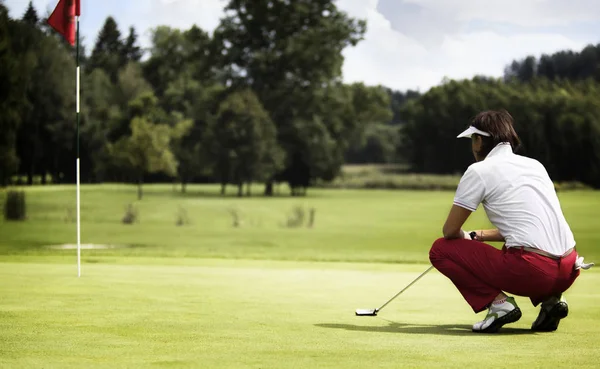 Giocatrice Golf Con Putter Squating Analizzare Verde Campo Golf — Foto Stock