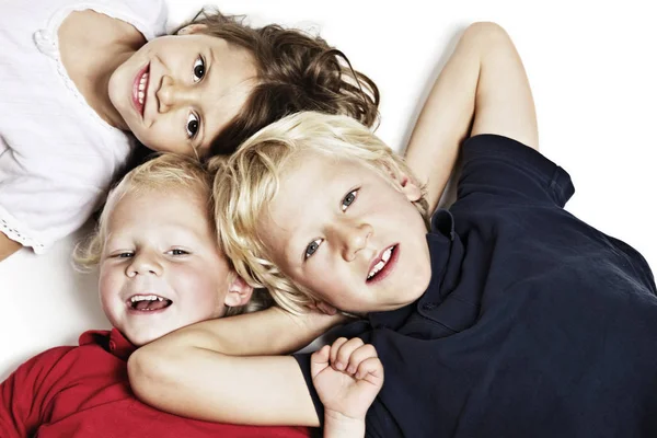 Smiling children on floor looking up — Stock Photo, Image